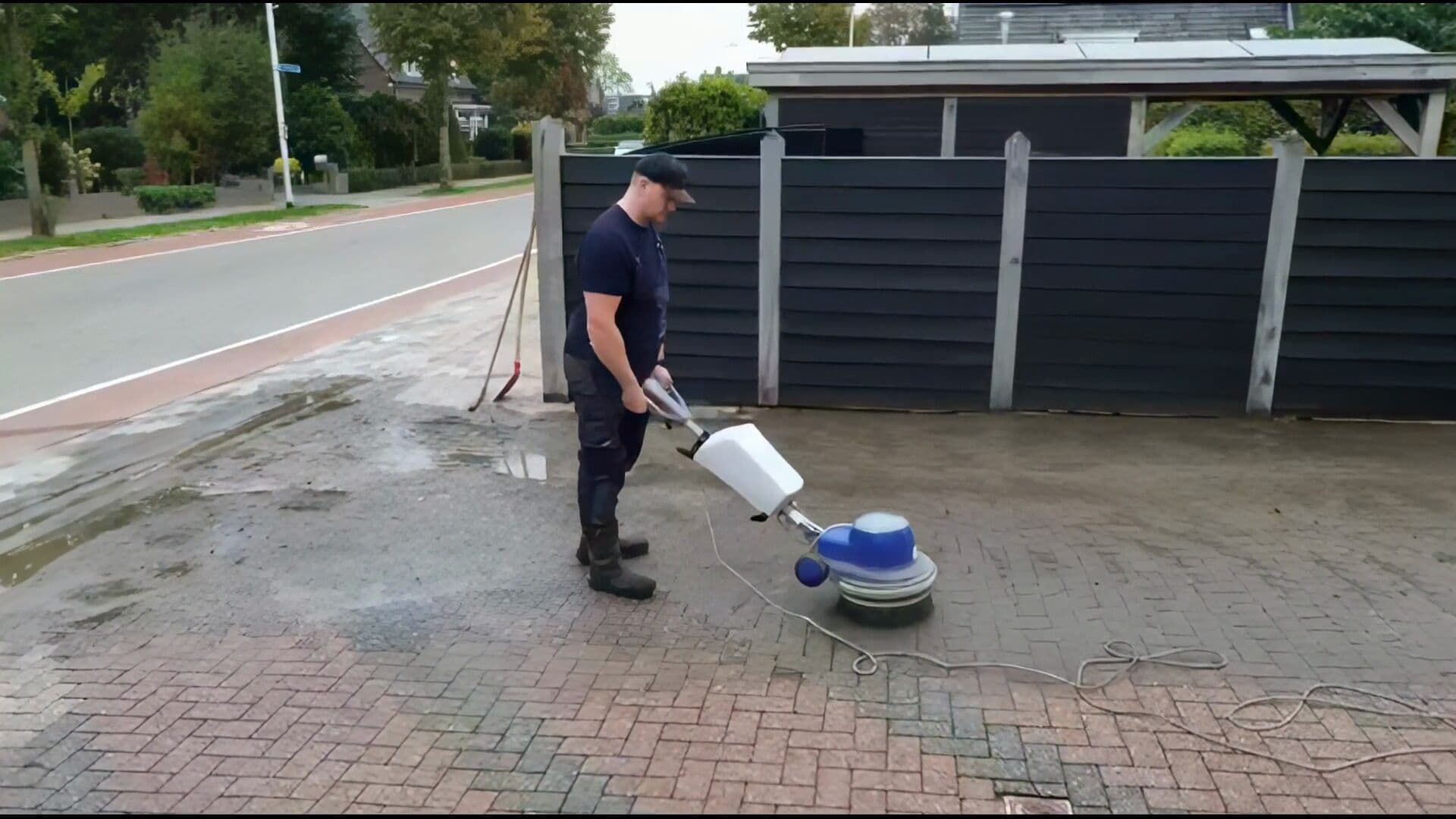 Oprit reinigen met borsteltechniek, van bovenaf gefilmd met een drone